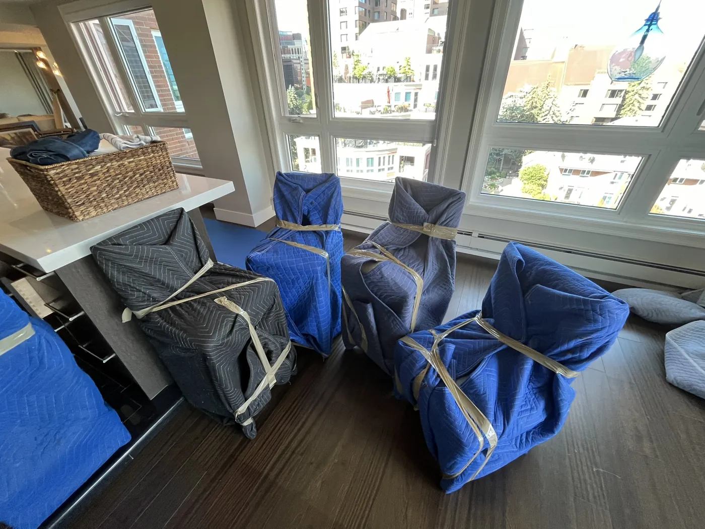 Chairs protected with padded moving blankets inside a home