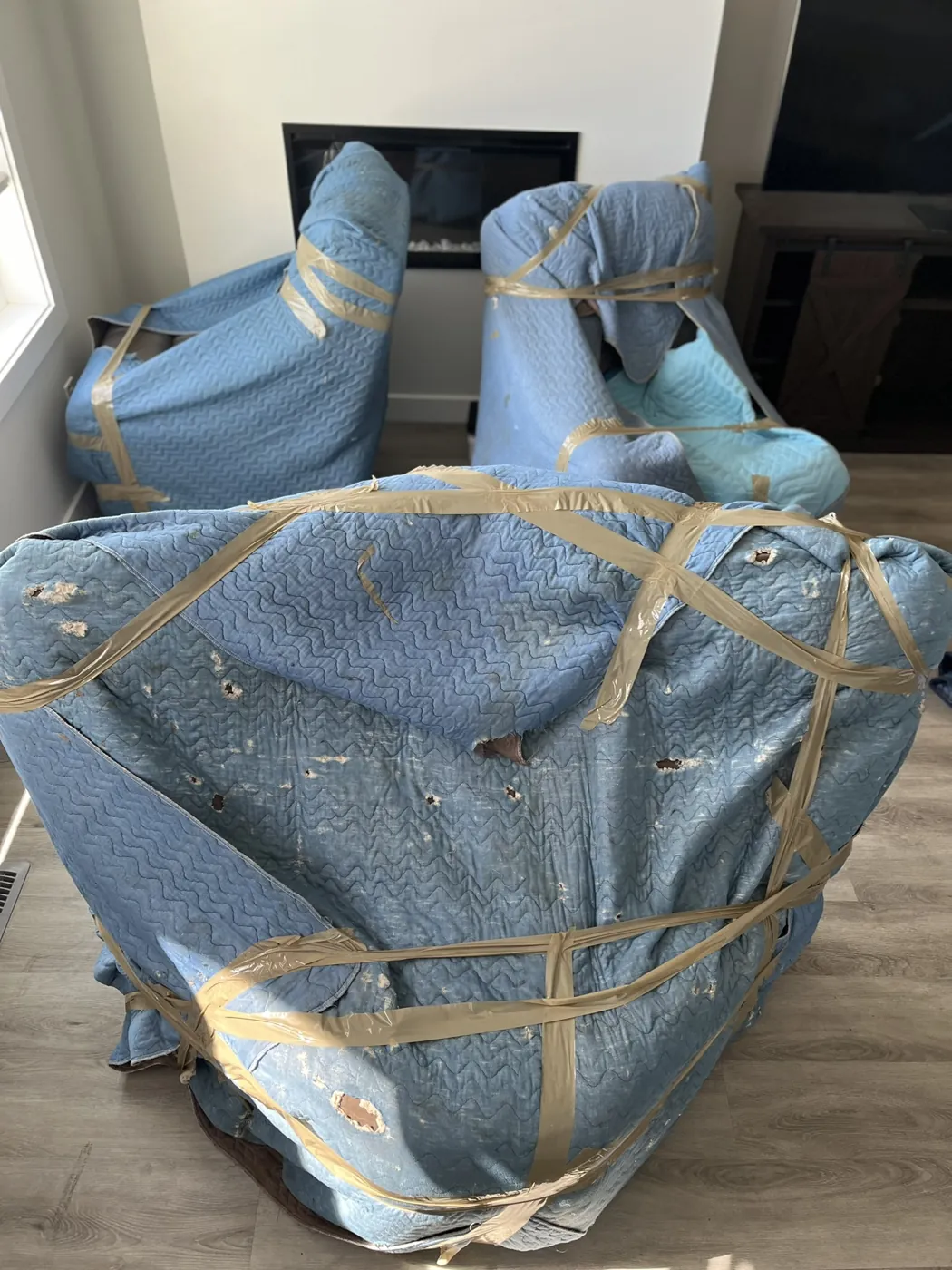 Chairs protected with padded moving blankets inside a home