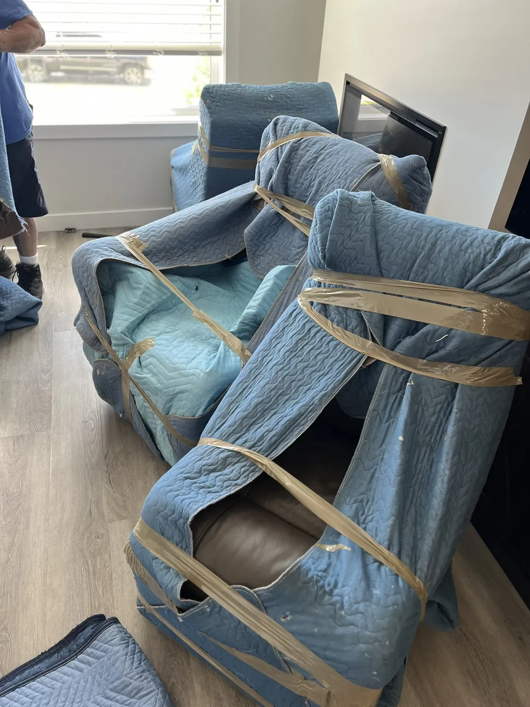 Chairs protected with padded moving blankets inside a home