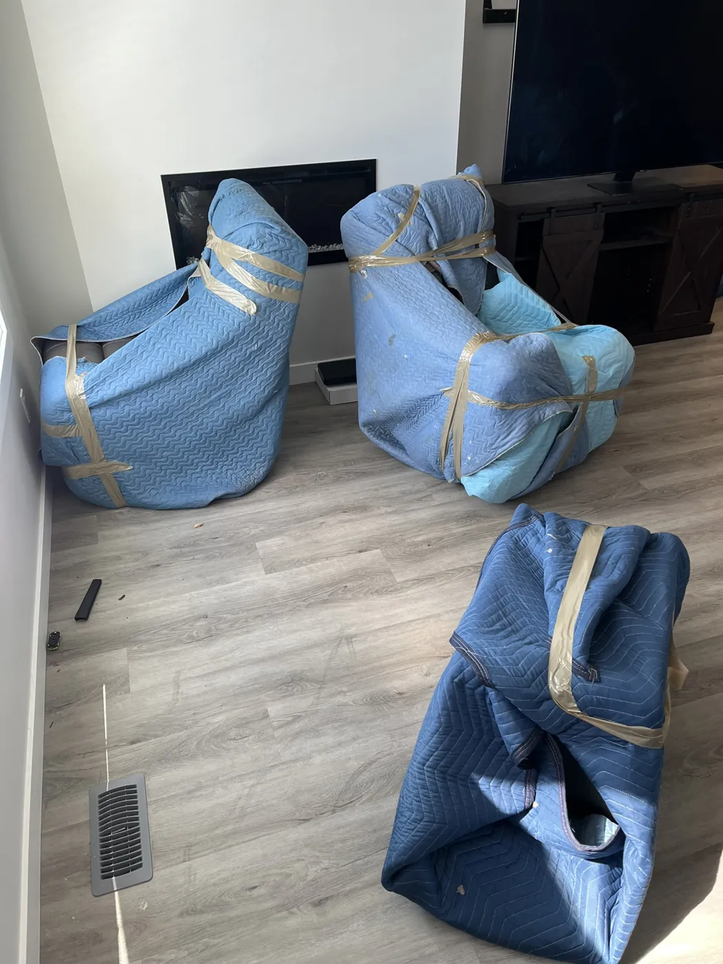 Chairs protected with padded moving blankets inside a home
