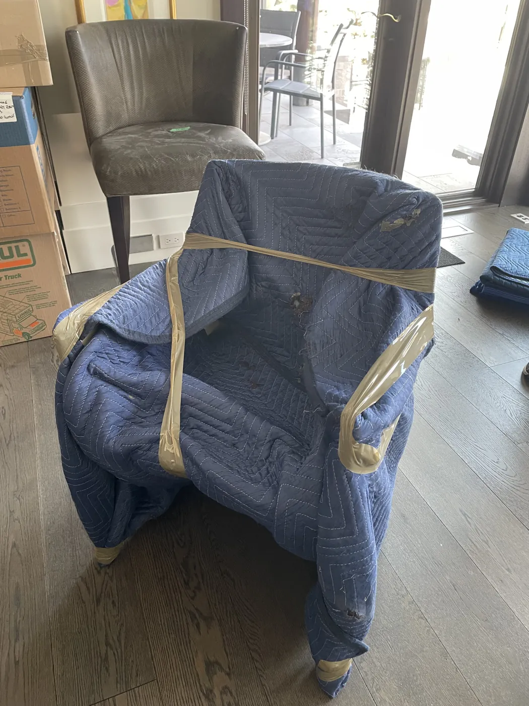 Chairs protected with padded moving blankets inside a home